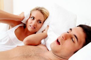 couple in scvhlafzimmer. husband snores loud and unpleasant.